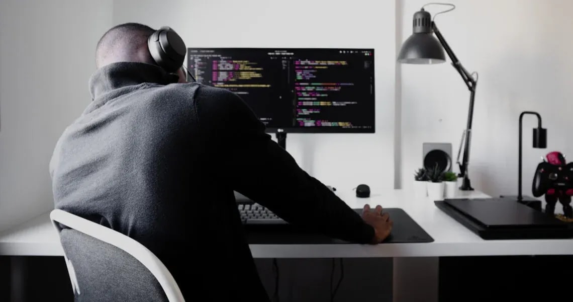 Man in front of monitor with code
